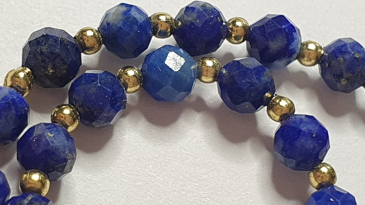 Zbliżenie naturalnego lapisu lazuli 4 mm i złotych elementów bransoletki